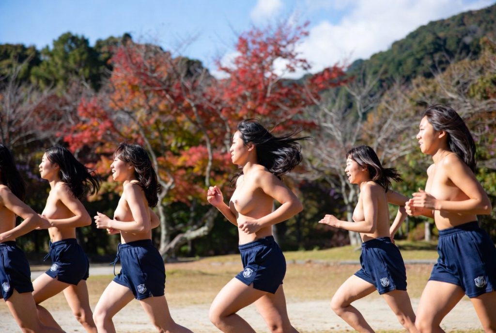 深霞学園大学における体育授業。女子学生が上半身裸で自然の中を走っている。