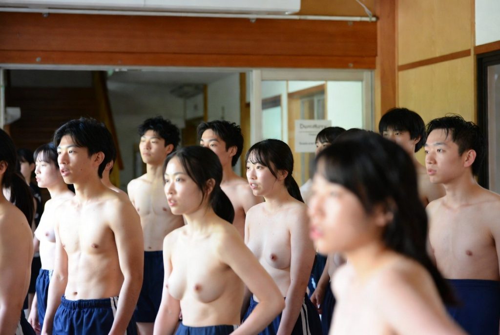 深霞学園大学における体育授業前のコミュニケーション。男女学生が上半身裸で集まっている。